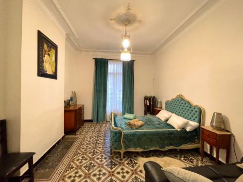 sypialnia z łóżkiem i kanapą w pokoju w obiekcie Appartement Dans Immeuble Haussmanien w mieście Algier