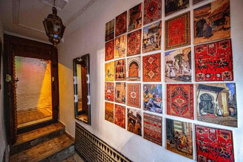 a wall filled with lots of pictures and a mirror at Riad Soultan in Fès