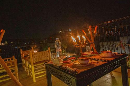 a table with plates of food on a balcony at night at Riad Soultan in Fès