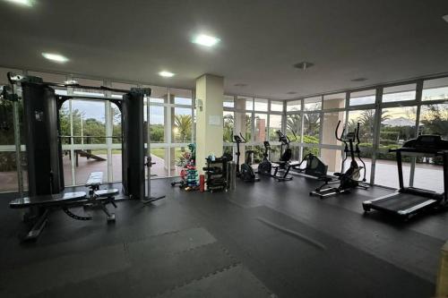 a gym with several treadmills and machines in a room at Lindo apartamento frente mar em condomínio club in Florianópolis