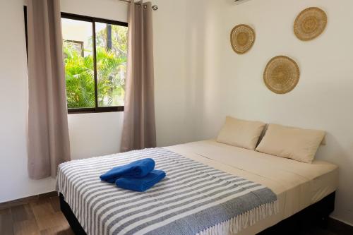 a bedroom with a bed with a blue towel on it at MY - Cosy Lodges in Paraíso