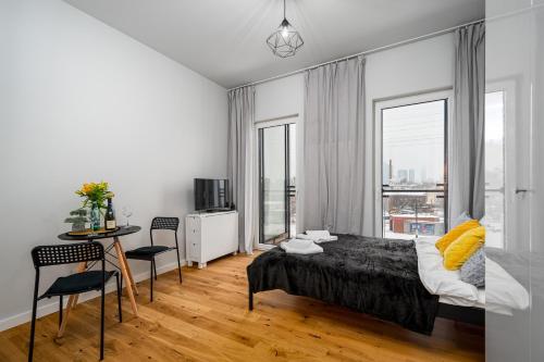a bedroom with a bed and a table and chairs at Apart D&K Free Parking Aleja Prymasa Tysiąclecia 83A in Warsaw