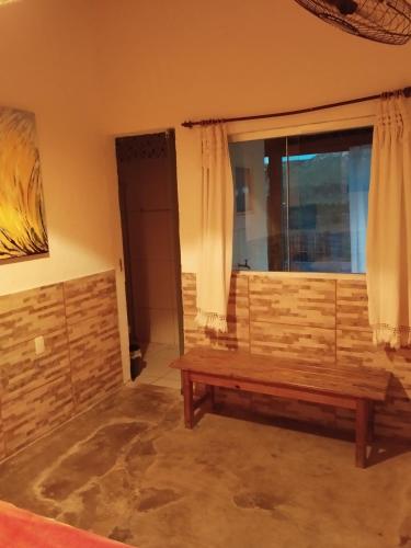 a room with a wooden bench in front of a window at Pouso do Elefante in Serra do Cipo