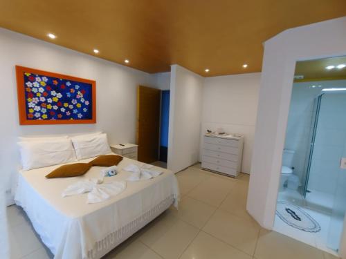 um quarto com uma cama grande e um chuveiro em Pousada Beira Mar - Suítes Frente ao mar em Torres