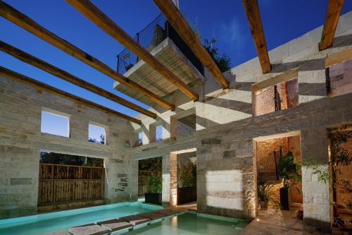 una piscina coperta in una casa con un muro di pietra di Amalen Suites Adults Only a Rethymno