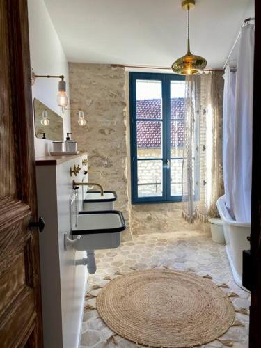 a bathroom with two sinks and a tub and a window at La Belle Vie du Vexin , à une heure de Paris in Parnes