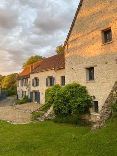 an old stone building with a grass yard next to it at La Belle Vie du Vexin , à une heure de Paris in Parnes