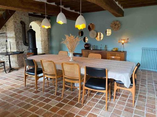 a dining room with a large table and chairs at La Belle Vie du Vexin , à une heure de Paris in Parnes