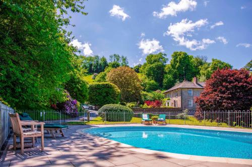 a swimming pool in a yard with a fence at Garden House in Totnes