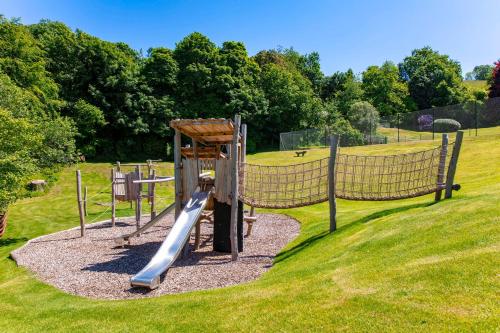 a playground with a slide in a park at Garden House in Totnes
