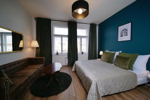 1 dormitorio con 1 cama y 1 sofá en Majestic Square View Residence, en Praga