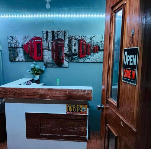 ein Badezimmer mit roten britischen Telefonzellen an der Wand in der Unterkunft RJ Travellers Inn in Catbalogan