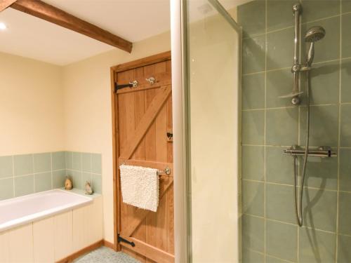 a bathroom with a shower and a tub and a sink at 3 Bed in Briston KT187 in Briston