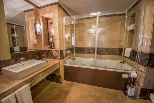 La salle de bains est pourvue d'une baignoire, d'un lavabo et d'une douche. dans l'établissement OttomanHotel, à Ankara