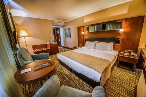 une chambre d'hôtel avec un lit et deux chaises dans l'établissement OttomanHotel, à Ankara