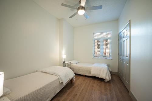 a bedroom with two beds and a ceiling fan at Classy Uptown Darling in Charlotte