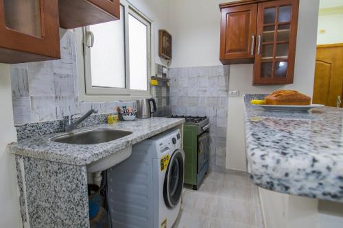 a kitchen with a sink and a dishwasher at Lazur Sea & City Apartment's - El Hadaba, Hurghada - Egypt in Hurghada