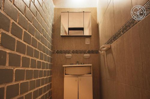 a small bathroom with a sink and a brick wall at El Progreso Molinos in Molinos