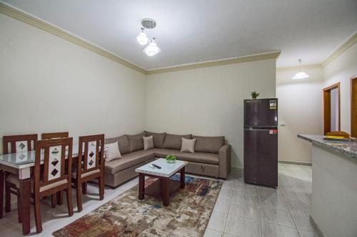 a living room with a couch and a refrigerator at Lazur Sea & City Apartment's - El Hadaba, Hurghada - Egypt in Hurghada