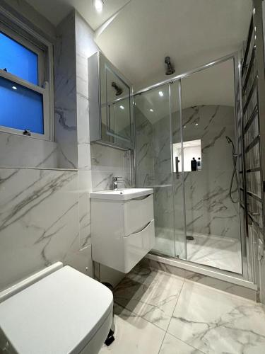 a bathroom with a shower and a toilet and a sink at Chic Studio Flat 8 Mins to Harrods Knightsbridge in London