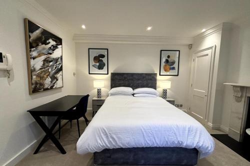 a bedroom with a bed and a desk with a bed sidx sidx sidx at Chic Studio Flat 8 Mins to Harrods Knightsbridge in London
