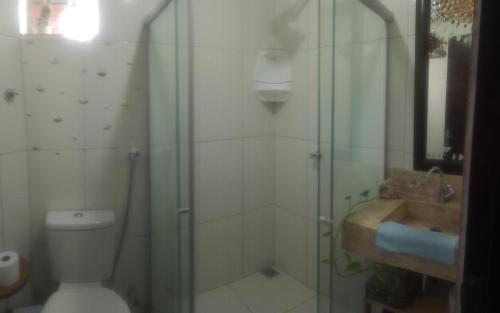 a bathroom with a shower and a toilet and a sink at A casinha do sonho in Lençóis