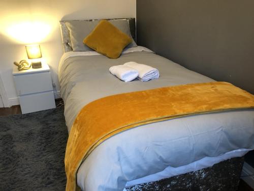 a bedroom with a bed with two towels on it at Comfortable Home From Home Bolton Central - Sleeps - 10 in Bolton