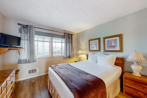 a bedroom with a large bed and a window at Nye Beach Condo in Newport