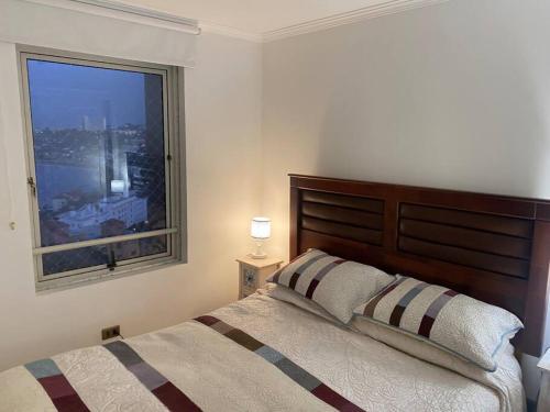 Un dormitorio con una cama grande y una ventana en Precioso depto vista al mar Concon Condominio Tipo Resort 2 dormitorios, en Concón