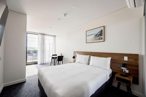 um quarto de hotel com uma cama e uma mesa em Durham Serviced Apartments em Adelaide