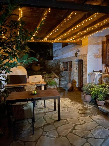a patio with a wooden table and string lights at Varousi House in Tríkala