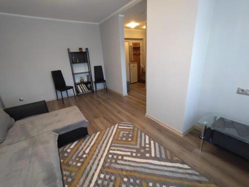 ein Wohnzimmer mit einem Sofa und einem Teppich in der Unterkunft Saknes apartamenti in Riga