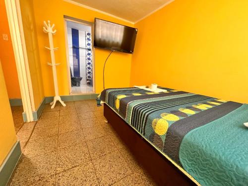 1 dormitorio con 1 cama y pared de color naranja en la casa azul, en Huarmey