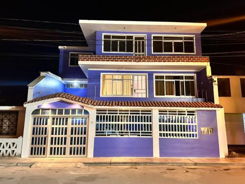 una casa azul con una valla blanca delante de ella en la casa azul, en Huarmey