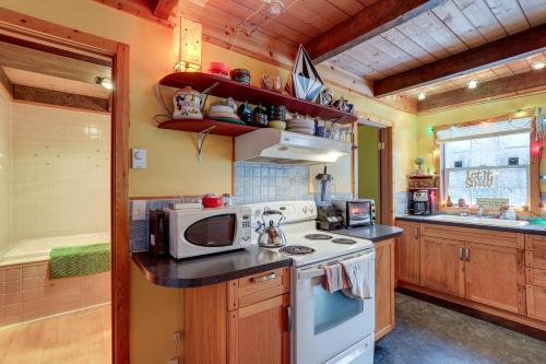 a kitchen with a stove and a microwave at Snoqualmie Pass Cabin with Deck Walk to Ski Lift in Snoqualmie Pass