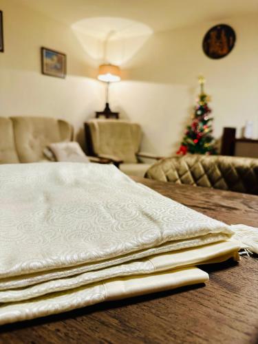 a white blanket on a wooden table with a christmas tree at Iepurasul Sinaia in Sinaia
