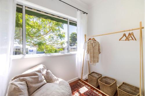 a bedroom with a window and a bed in a room at Evoke - Shoal Bay, 2 Leonard Ave , Stylish holiday house with air con, Wi-Fi & boat parking in Shoal Bay