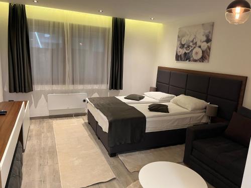 Un dormitorio con una cama grande y un sofá. en Apart Hotel & spa Zoned II, Kopaonik, apartman Lukač - special benifit Children up to 13 of age accompanied by two adutls staj for free! FREE PARKING!, en Kopaonik