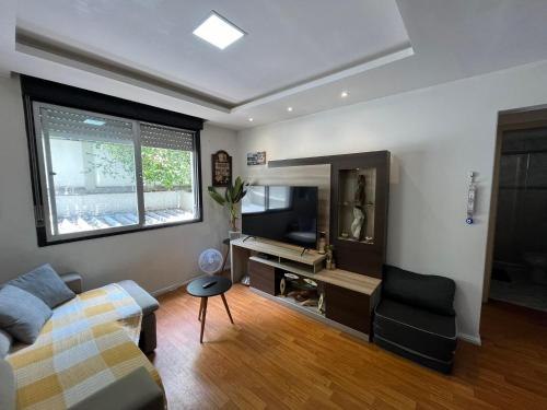 uma sala de estar com um sofá e uma secretária em Apartamento Bem Localizado no Centro de Porto Alegre em Porto Alegre