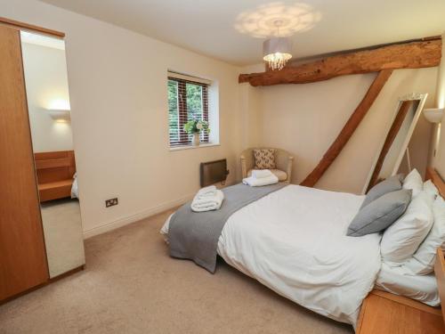 a bedroom with a large bed and a mirror at The Wheat House in Stratford-upon-Avon