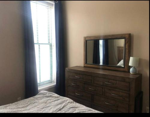 - une chambre avec une commode avec un miroir et un lit dans l'établissement Jefferson street Loft, à Burlington