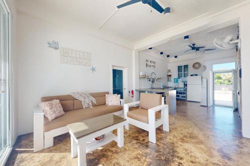 a living room with a couch and a kitchen at White Sands Beach House in Maya Beach