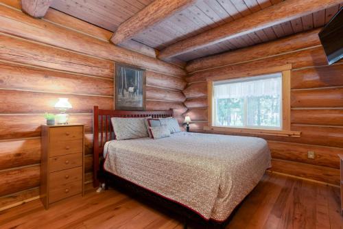 a bedroom with a bed in a log cabin at Fairlight Hollow in Bend