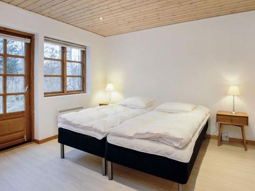 a bedroom with a large bed and a window at Holiday home Læsø in Læsø