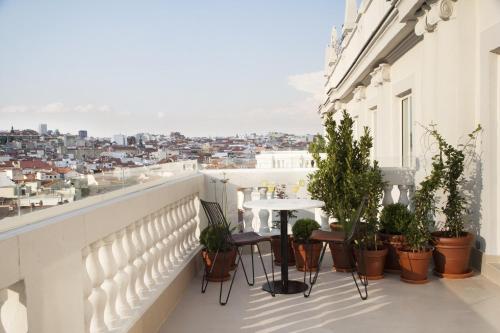 a patio area with chairs, tables and umbrellas at Dear Hotel Madrid in Madrid