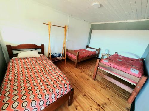 a bedroom with two beds and a chair in it at LÖF Hostal in Pichilemu