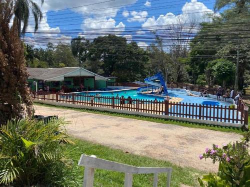 uma piscina num parque com uma cerca de madeira em Chalé simples em camping com bastante movimento em Atibaia