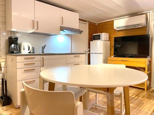 a kitchen with a white table and a white refrigerator at Houses by The Sea in Salpar