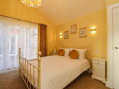 a bedroom with a white bed and a window at Summerseats Cottage in Alnwick