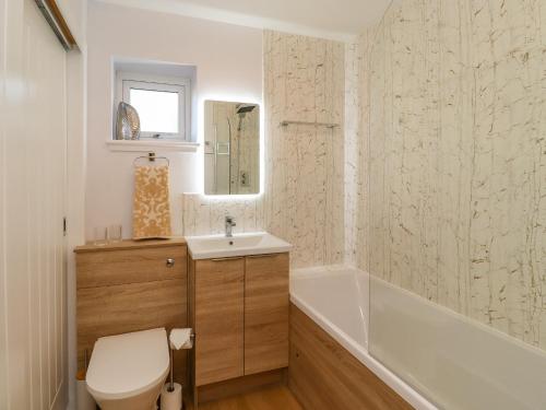 een badkamer met een toilet, een wastafel en een bad bij Summerseats Cottage in Alnwick